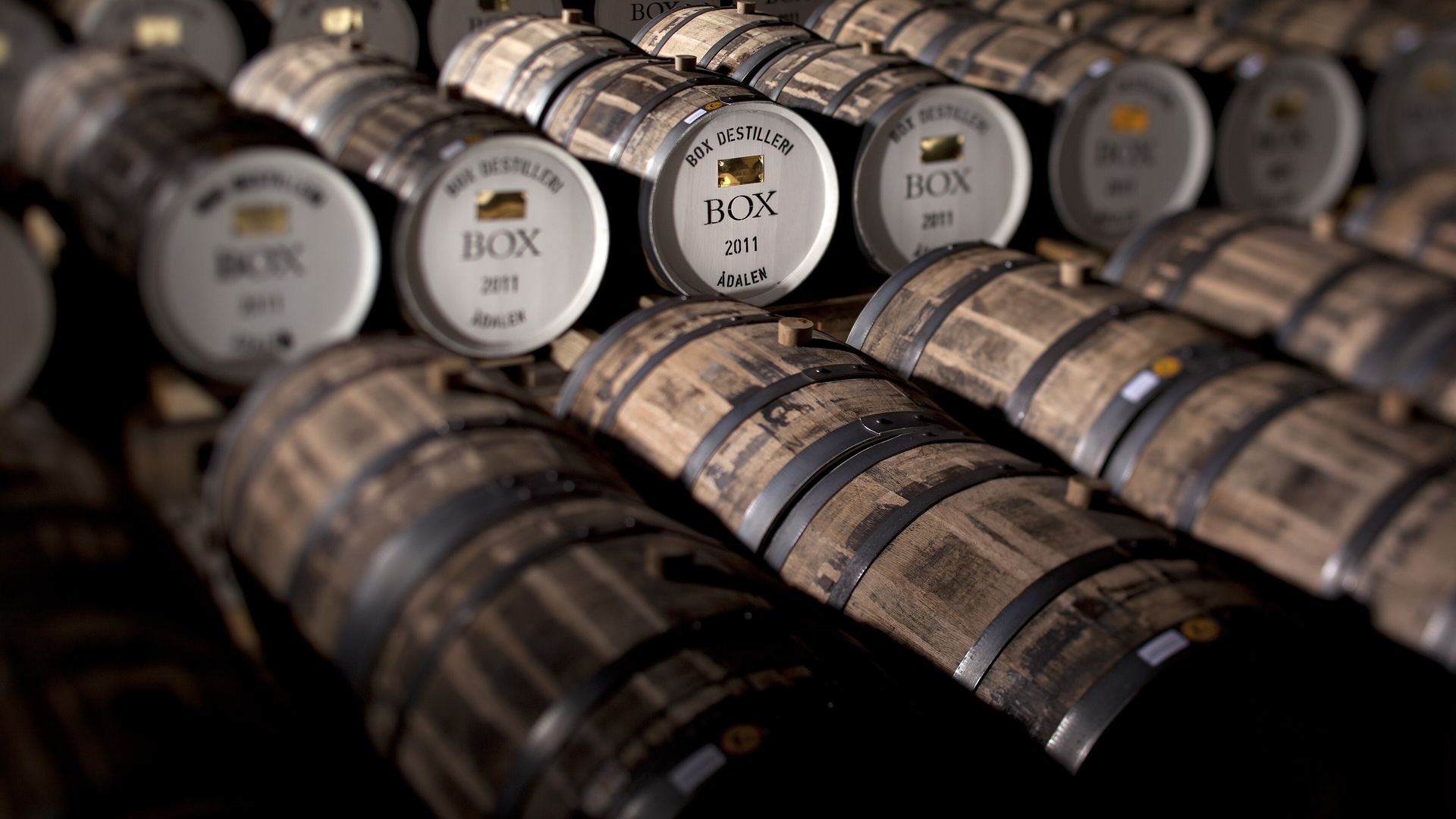 Whisky casks and bottles, background for our whisky glossary of terms