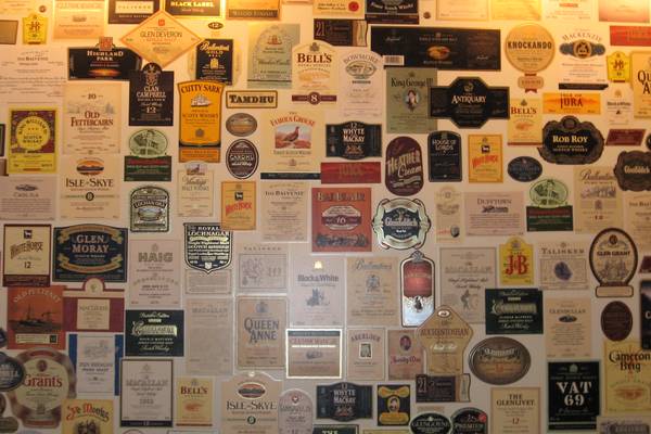 Wall covered with dozens of vintage Scotch whisky labels